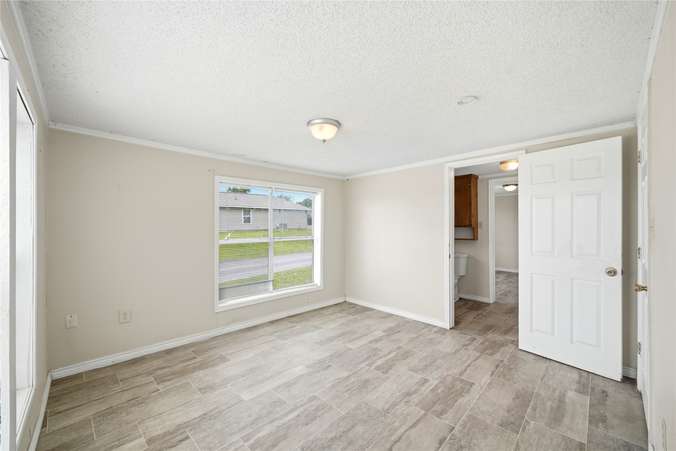 101 Outlar Street Wharton, TX 77488 - Photo 17 of 40 an empty room with wooden floor cabinet and windows