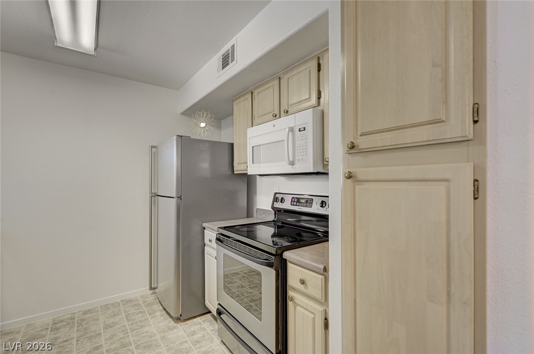 555 East Silverado Ranch Boulevard, Unit 2124 Las Vegas, NV 89183 - Photo 16 of 47 Functional kitchen with ample cabinetry and essential appliances.