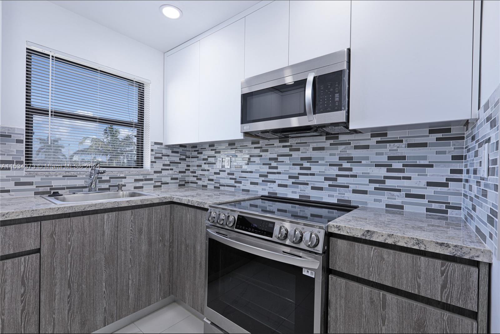 Flamingo-Lummus Miami Beach, FL 33139 - Photo 10 of 16 a kitchen with granite countertop a stove sink and microwave