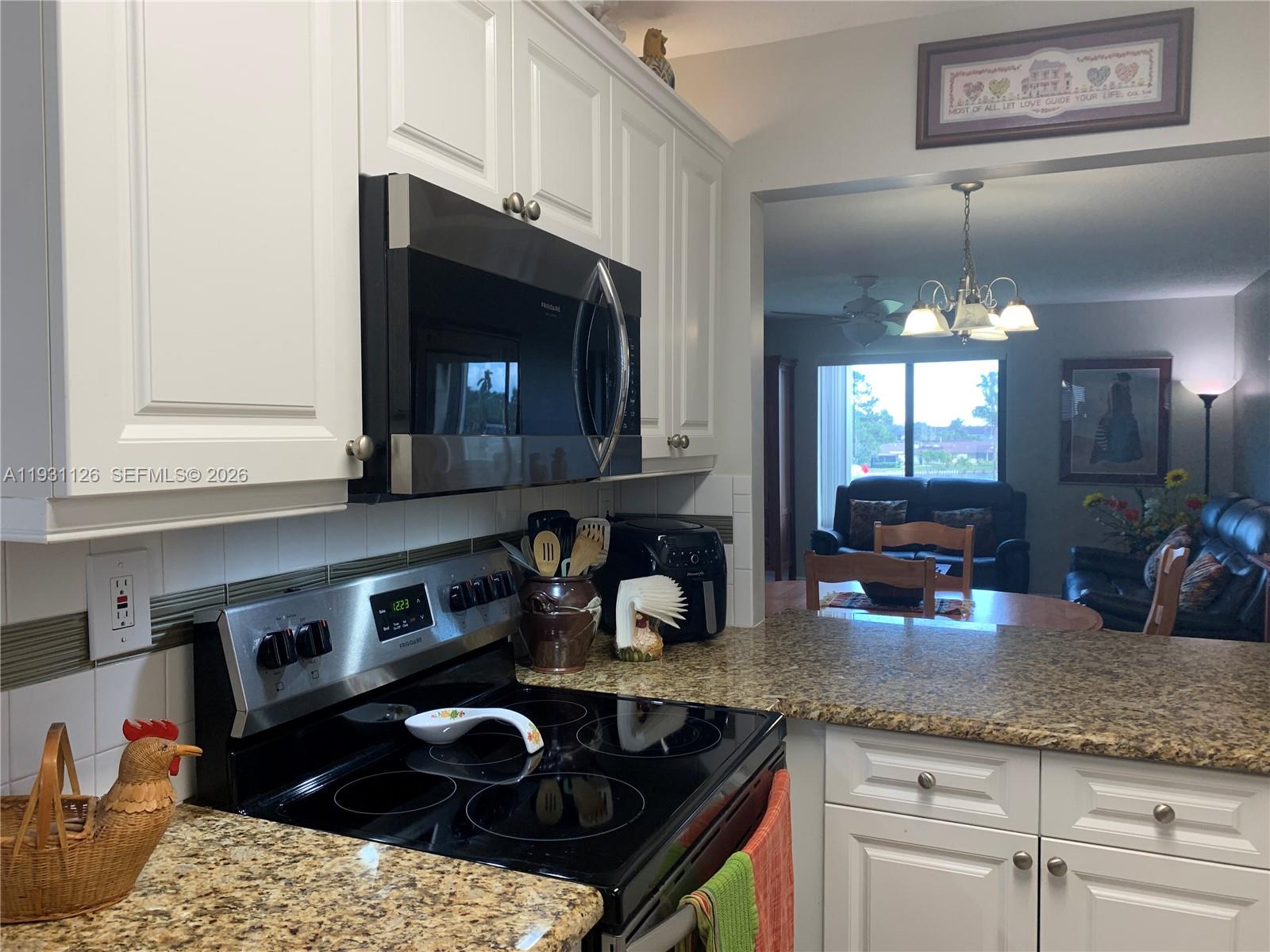 5463 Southeast Miles Grant Road, Unit 210 Stuart, FL 34997 - Photo 11 of 53 a kitchen with granite countertop cabinets a sink and a stove