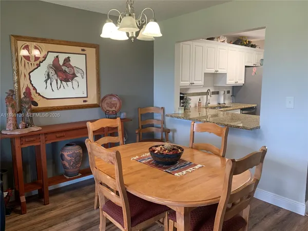 a view of a dining room with furniture a chandelier and wooden floor