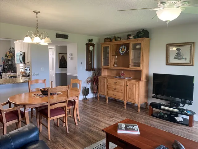 a living room with furniture a chandelier and a flat screen tv