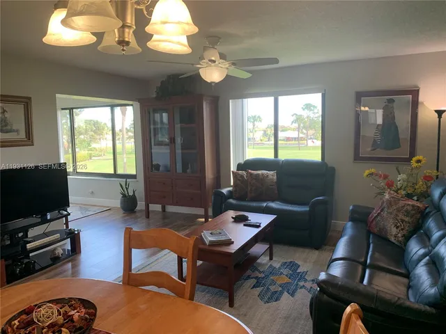 a living room with furniture a flat screen tv and a large window