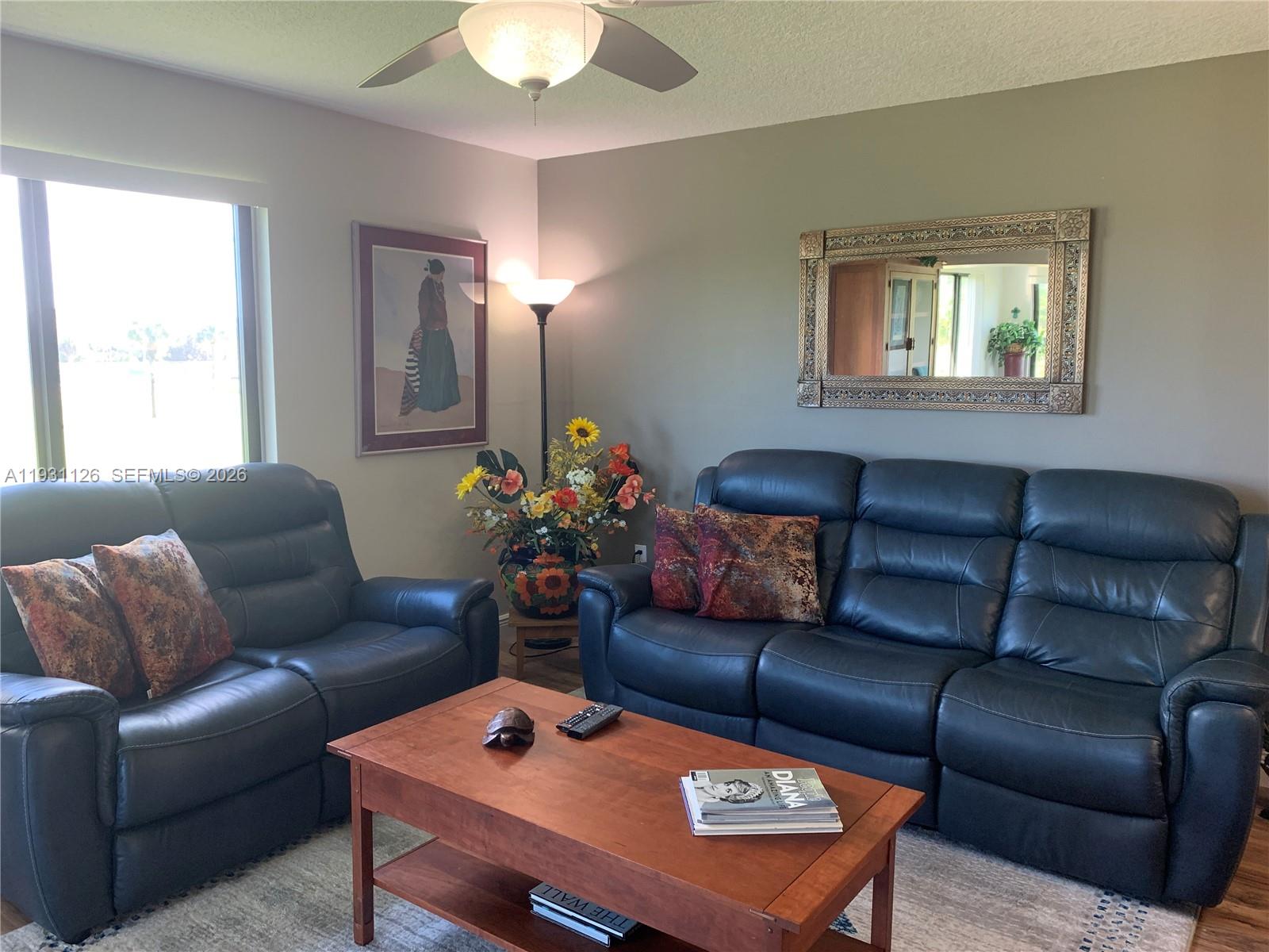 5463 Southeast Miles Grant Road, Unit 210 Stuart, FL 34997 - Photo 21 of 53 a living room with furniture a table and a window