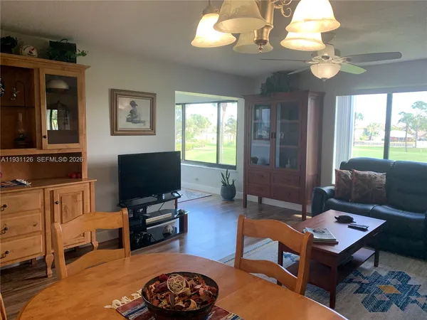 a living room with furniture a flat screen tv and a large window