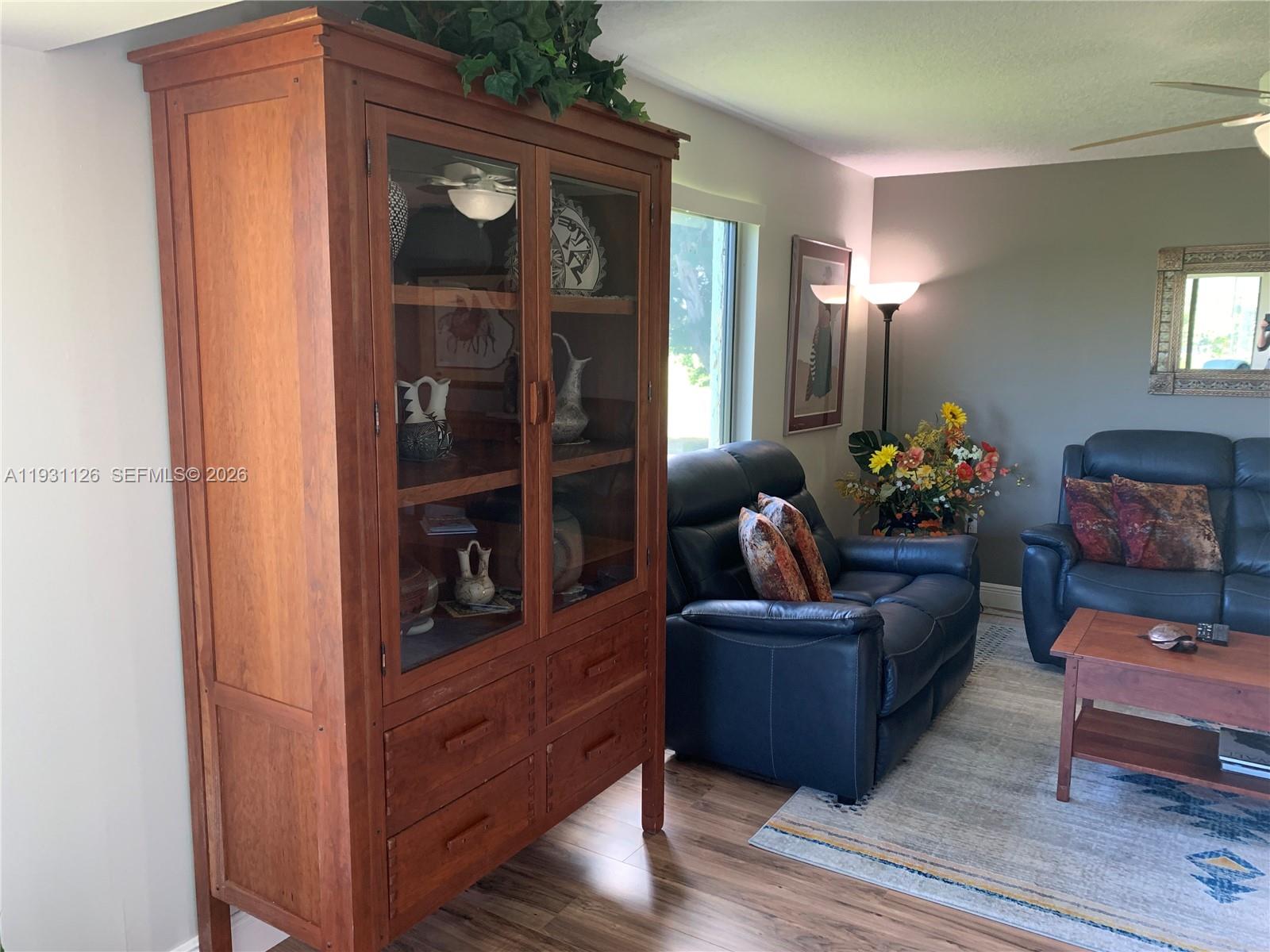 5463 Southeast Miles Grant Road, Unit 210 Stuart, FL 34997 - Photo 24 of 53 a living room with furniture and wooden floor