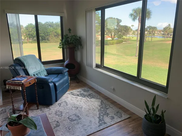 a living room with furniture and a floor to ceiling window