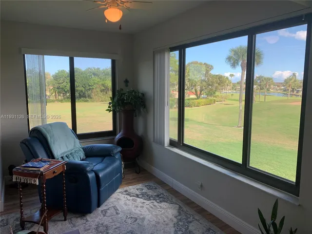 a living room with furniture and a floor to ceiling window