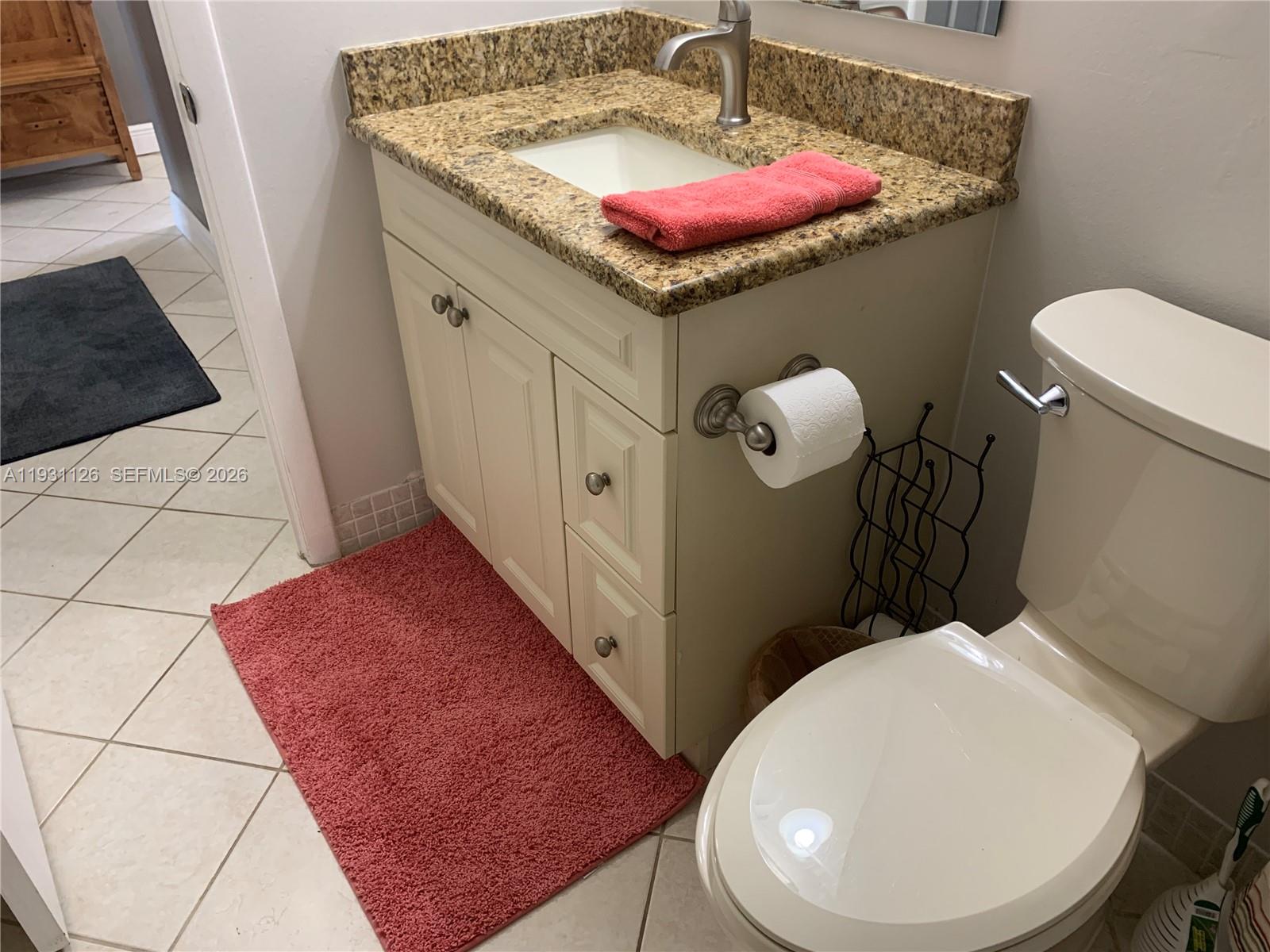 5463 Southeast Miles Grant Road, Unit 210 Stuart, FL 34997 - Photo 33 of 53 a bathroom with a toilet sink and mirror
