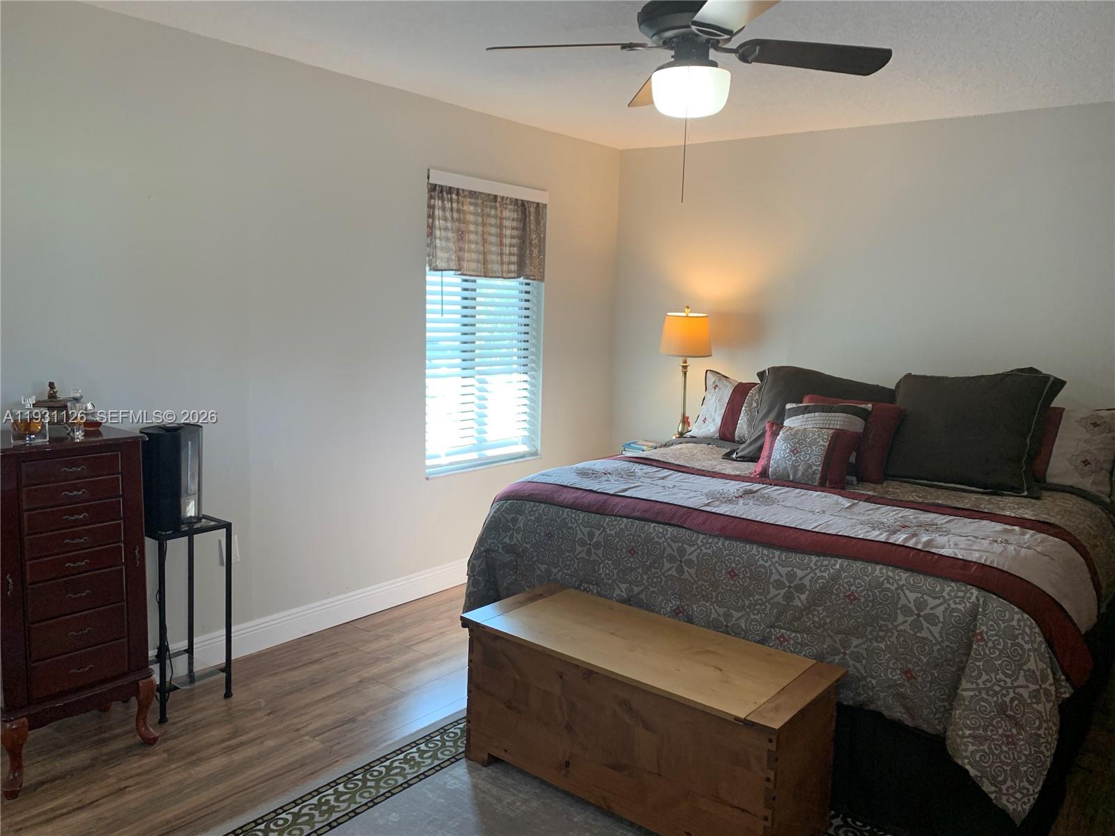 5463 Southeast Miles Grant Road, Unit 210 Stuart, FL 34997 - Photo 38 of 53 a bedroom with a bed and a chandelier