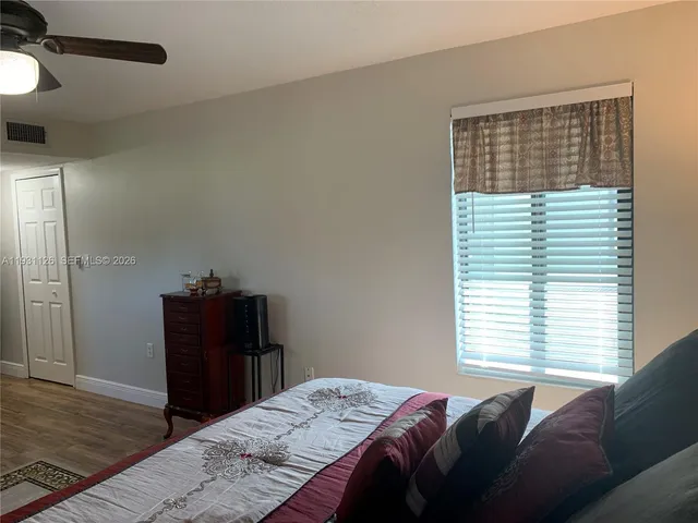 a bedroom with a large bed and wooden floor