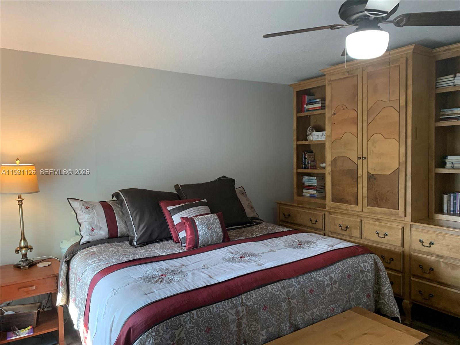 5463 Southeast Miles Grant Road, Unit 210 Stuart, FL 34997 - Photo 40 of 53 a bedroom with a large bed and wooden floor