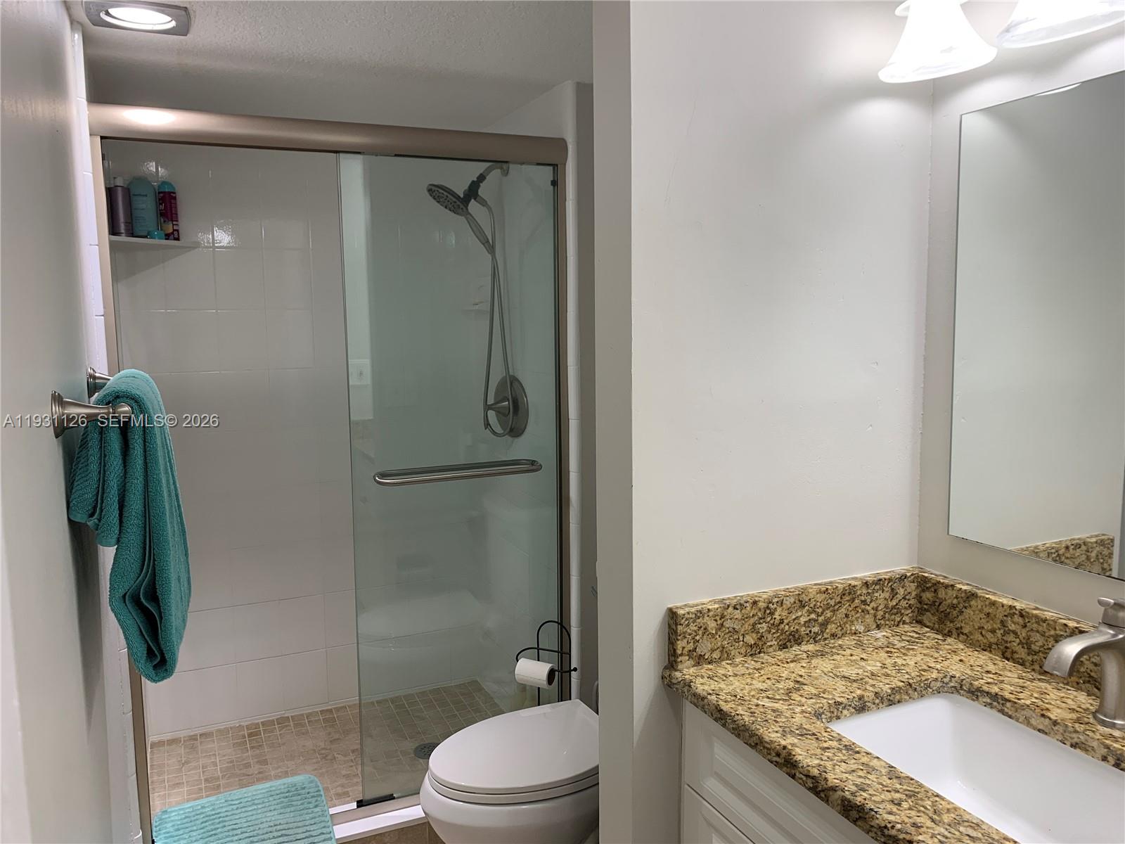 5463 Southeast Miles Grant Road, Unit 210 Stuart, FL 34997 - Photo 46 of 53 a bathroom with a granite countertop sink toilet and shower