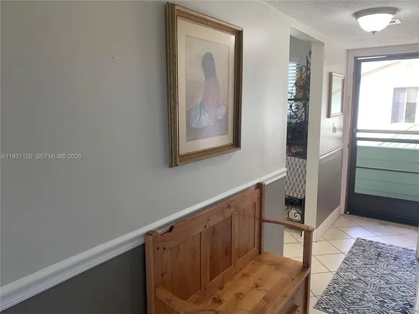 a hallway with painting on the wall and a potted plant