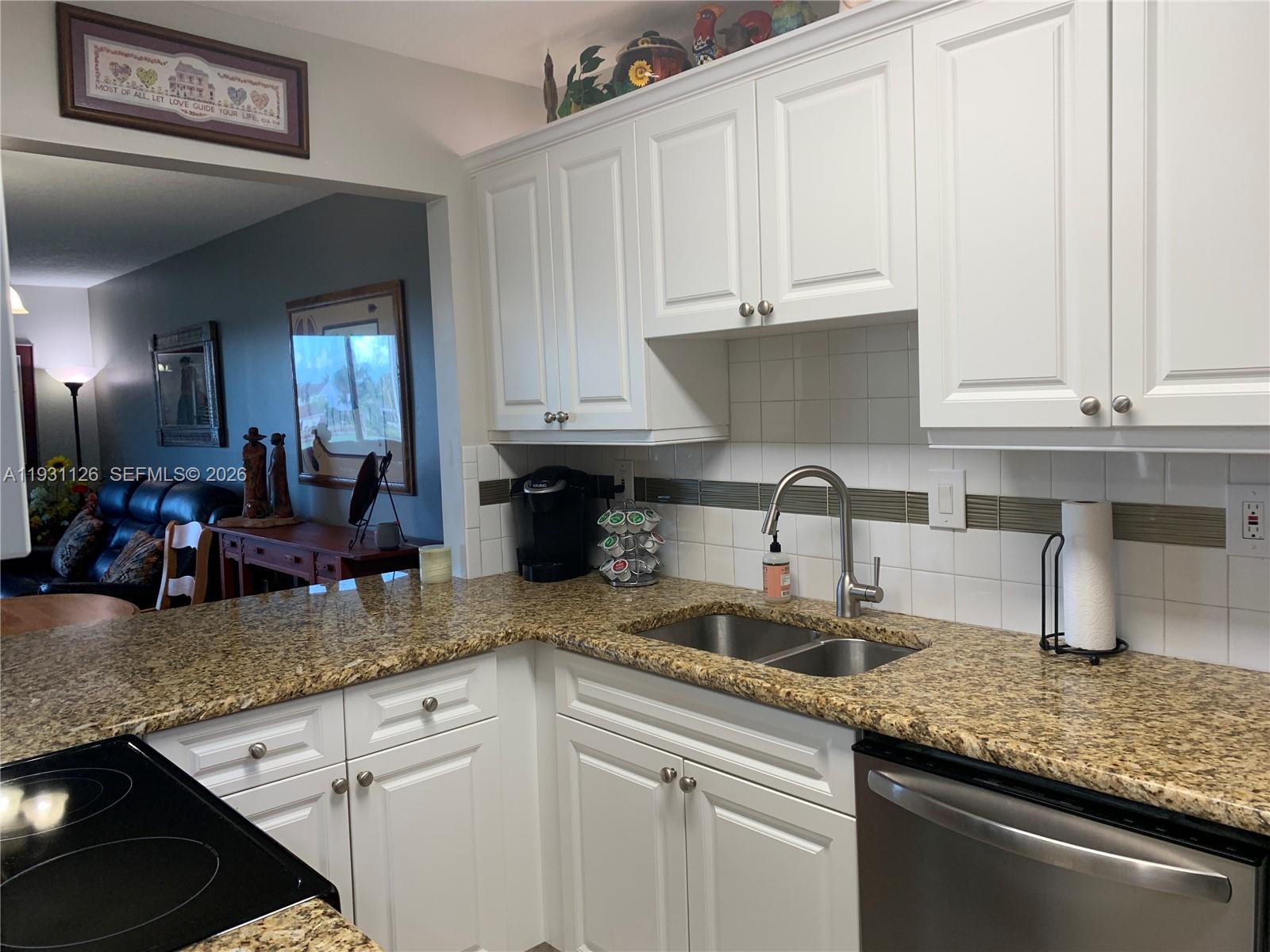 5463 Southeast Miles Grant Road, Unit 210 Stuart, FL 34997 - Photo 9 of 53 a kitchen with granite countertop a sink a stove and cabinets