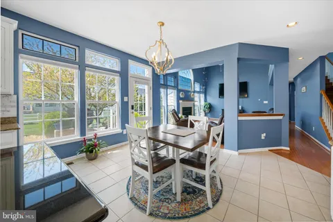 a dining room with furniture a chandelier and wooden floor