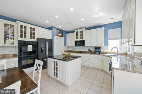 a kitchen with stainless steel appliances kitchen island granite countertop a sink and cabinets