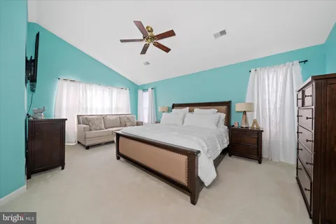 a bedroom with a bed couch and a window