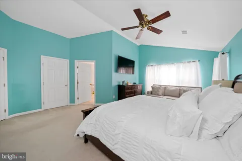 a bedroom with a bed and a ceiling fan