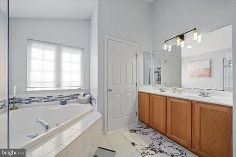a spacious bathroom with a tub sink shower and mirror
