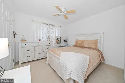 a bedroom with a bed and a ceiling fan