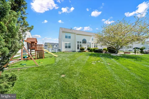 a view of a house with a big yard and large trees