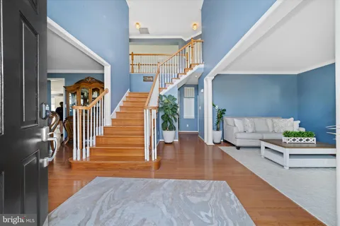 a hallway with wooden floors stairs and a couch