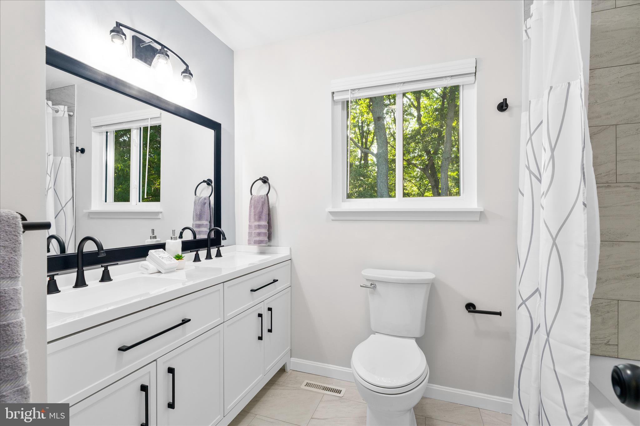 3908 Shakespeare Way Monrovia, MD 21770 - Photo 38 of 59 a bathroom with a toilet a sink a mirror a window and vanity