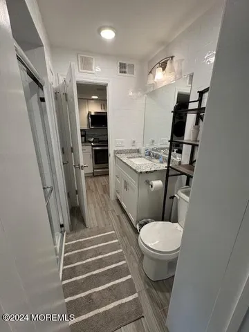 a bathroom with a sink a toilet a mirror and shower