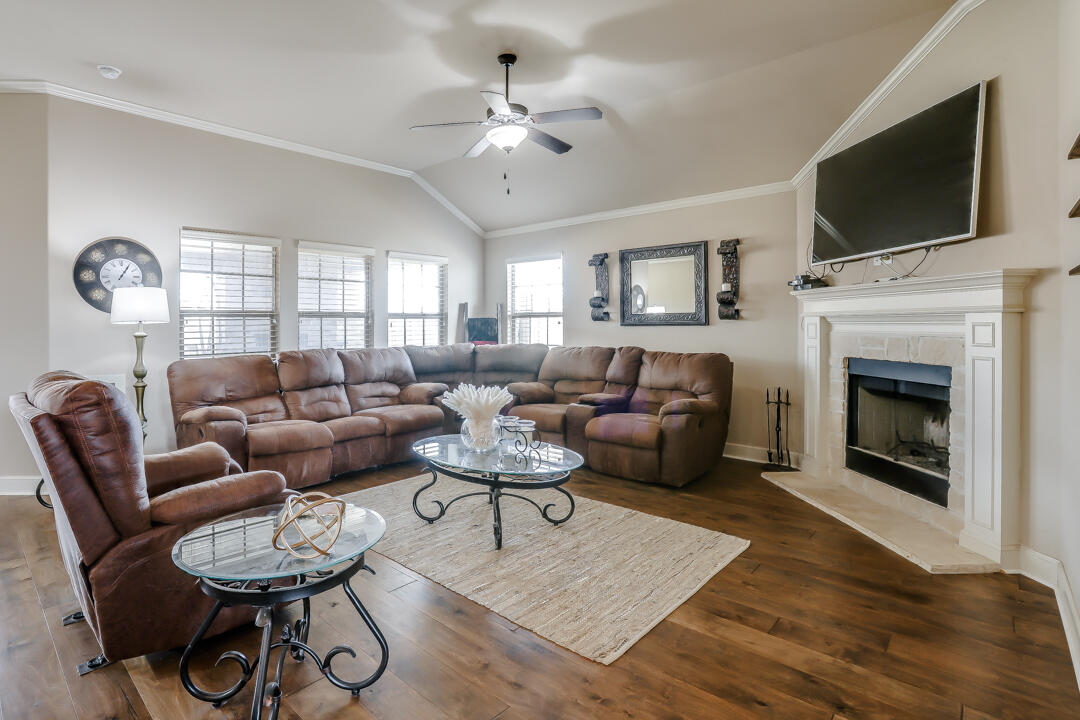 6502 71st Street Lubbock, TX 79424 - Photo 2 of 21 a living room with furniture a fireplace and a flat screen tv