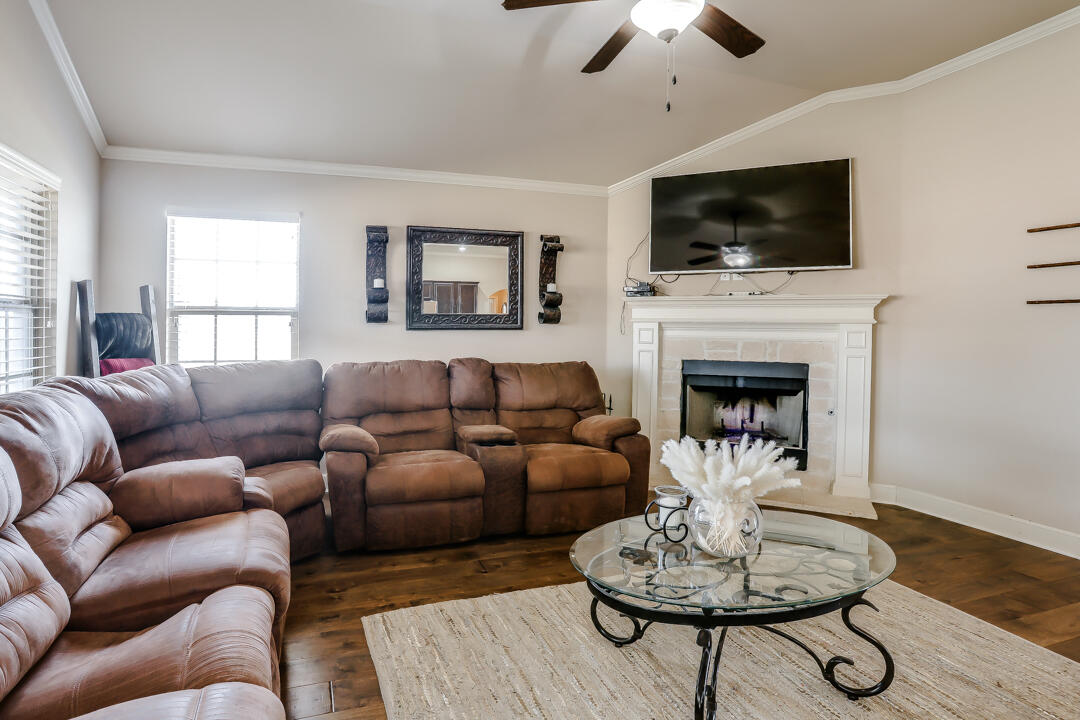 6502 71st Street Lubbock, TX 79424 - Photo 4 of 21 a living room with furniture a fireplace and a flat screen tv