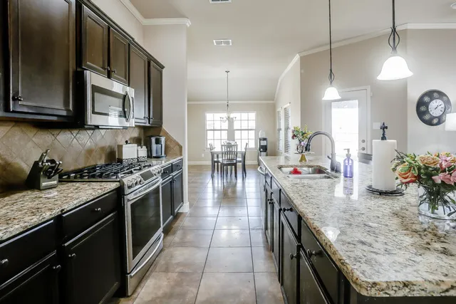 a kitchen with kitchen island granite countertop a table and chairs in it