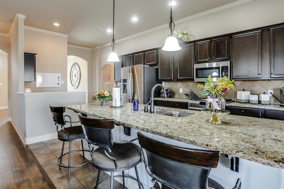 6502 71st Street Lubbock, TX 79424 - Photo 9 of 21 a kitchen with kitchen island granite countertop a table and chairs in it
