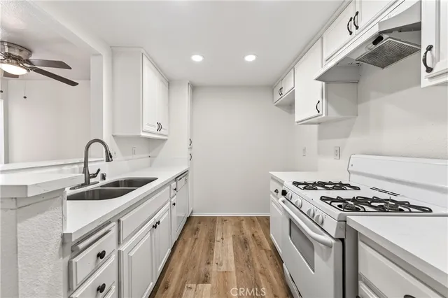 a kitchen with stainless steel appliances a sink a stove and a refrigerator