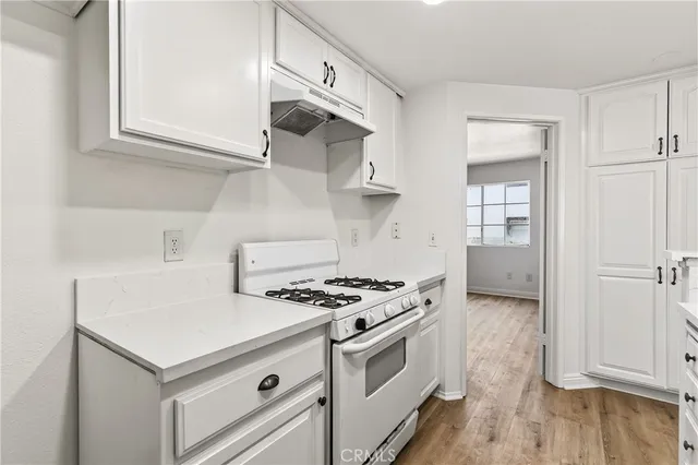 a kitchen with white cabinets and white appliances