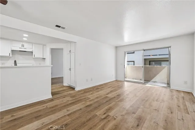 a view of a kitchen with wooden floor and a sink