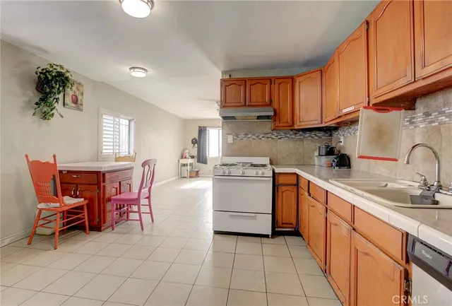 a kitchen with a sink white cabinets and appliances