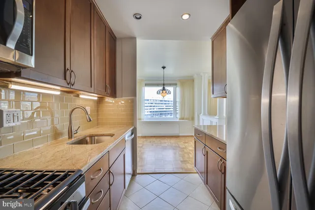a kitchen with granite countertop a refrigerator and a stove top oven