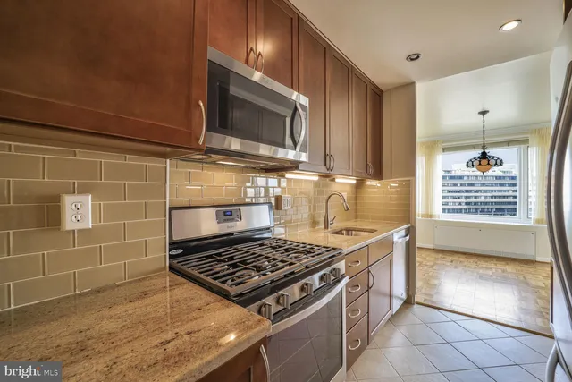 a kitchen with granite countertop a stove and a sink
