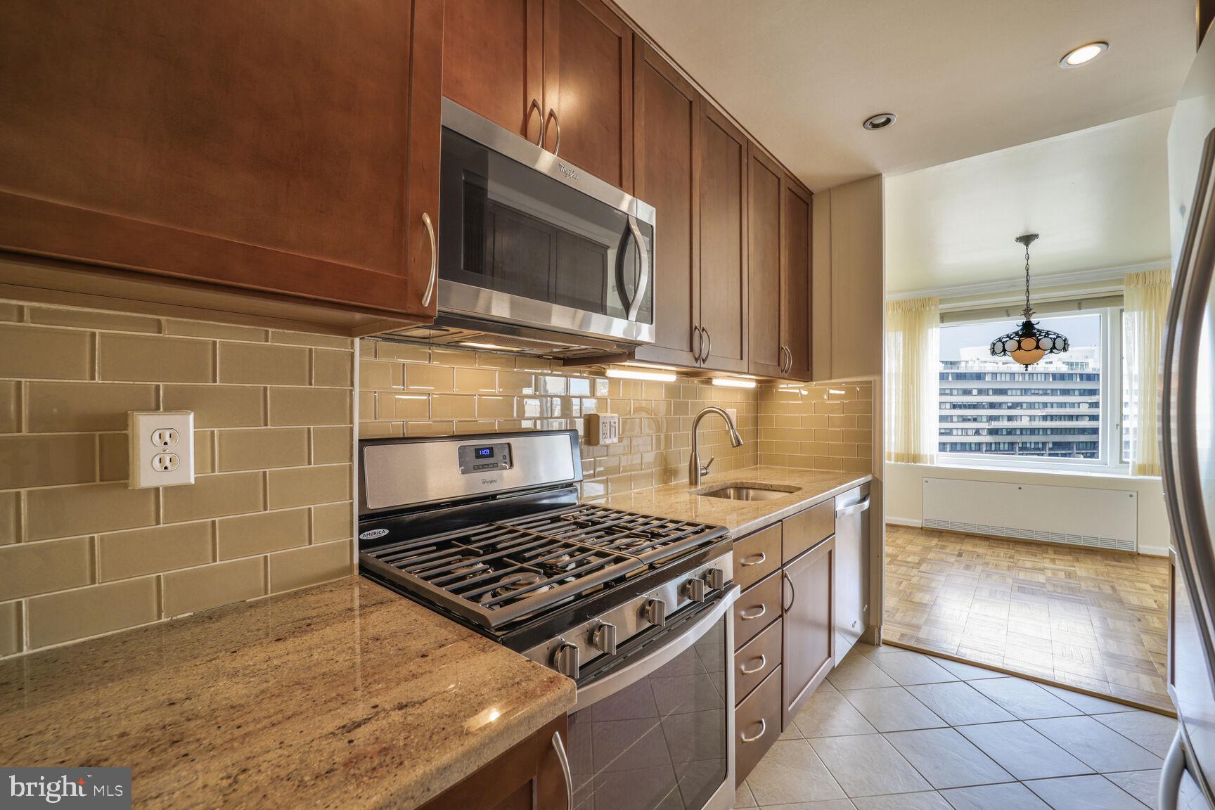 2475 Virginia Avenue Northwest, Unit 930 Washington, DC 20037 - Photo 15 of 42 a kitchen with granite countertop a stove and a sink