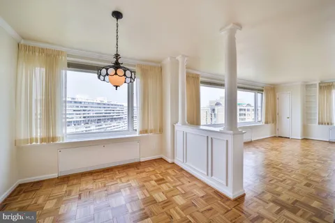 a view of an empty room with window and cabinet