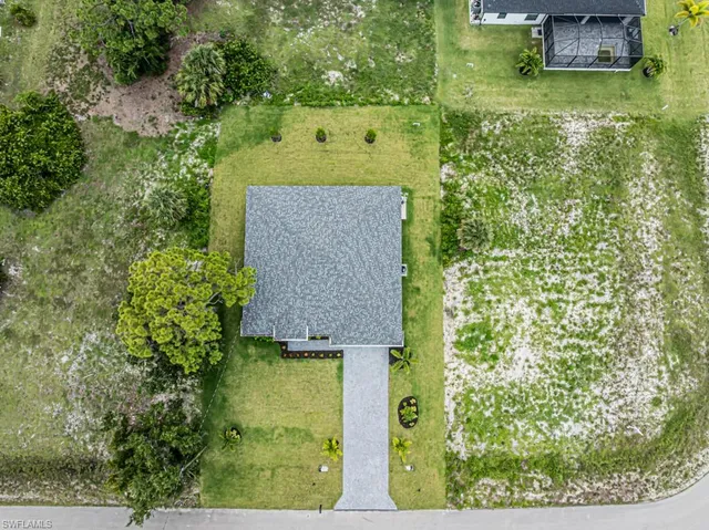 an aerial view of a house with a yard basket ball court and outdoor seating