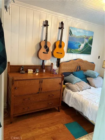 a bedroom with a bed and painting on the wall