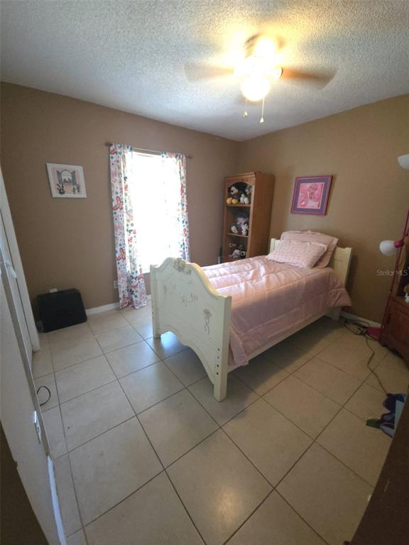 7818 Lewis Road Lakeland, FL 33810 - Photo 11 of 13 a bedroom with a bed and a table in it