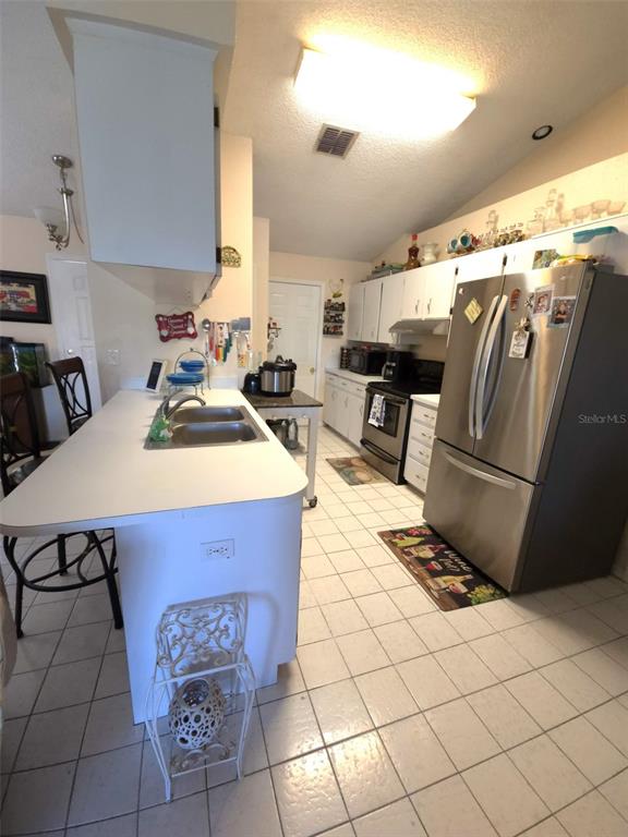 7818 Lewis Road Lakeland, FL 33810 - Photo 7 of 13 a kitchen with a sink a stove and a refrigerator