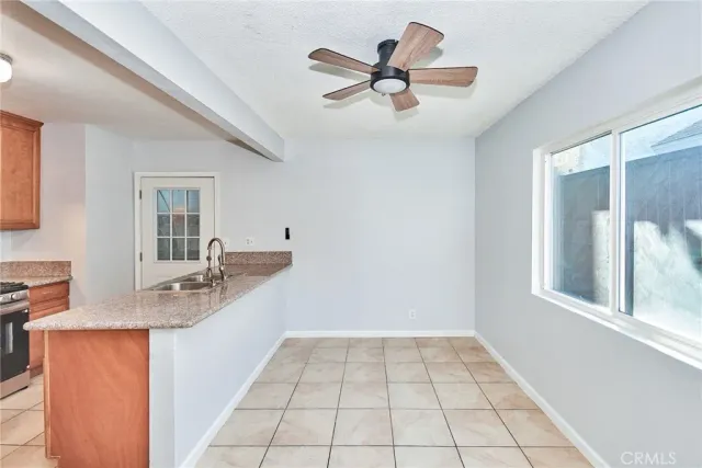 an empty room with windows and ceiling fan