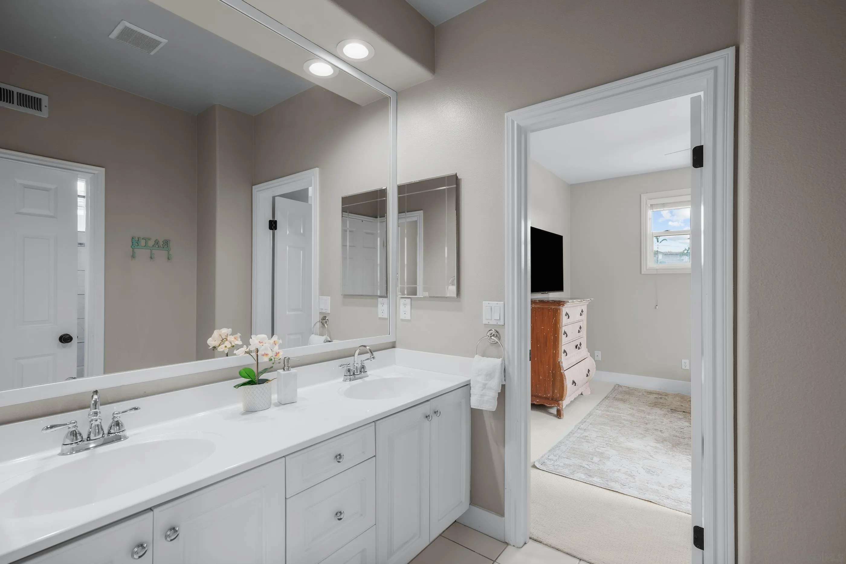 6402 Topmast Drive Carlsbad, CA 92011 - Photo 39 of 53 a bathroom with double sink and a mirror