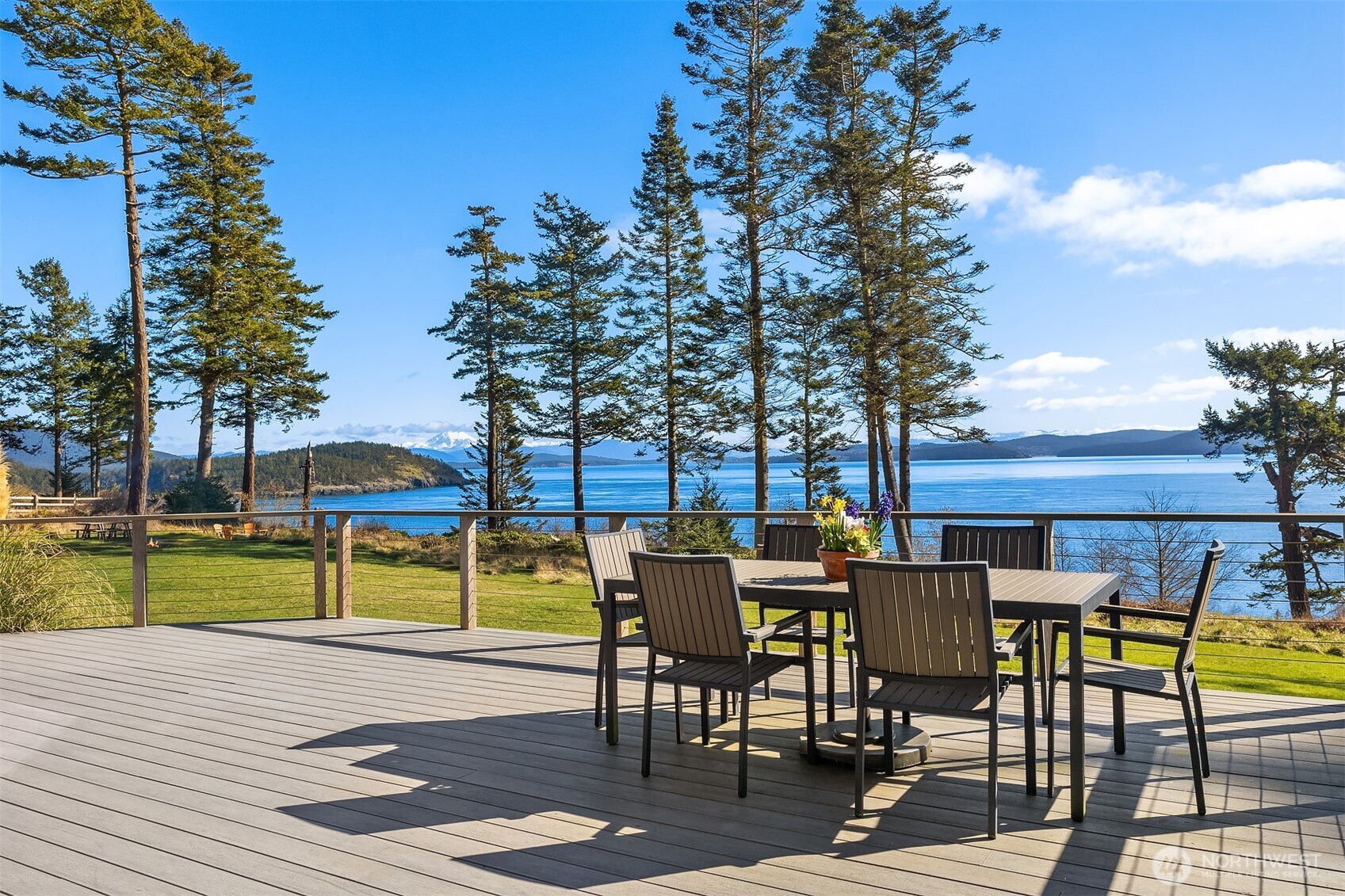 346 Thatcher Pass Road Decatur Island, WA 98221 - Photo 20 of 39 a view of a patio with table and chairs and potted plants with wooden floor and fence