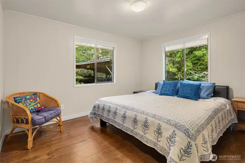 a bedroom with a bed table chair and a window