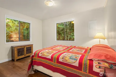 a bedroom with a bed and a stove next to a window